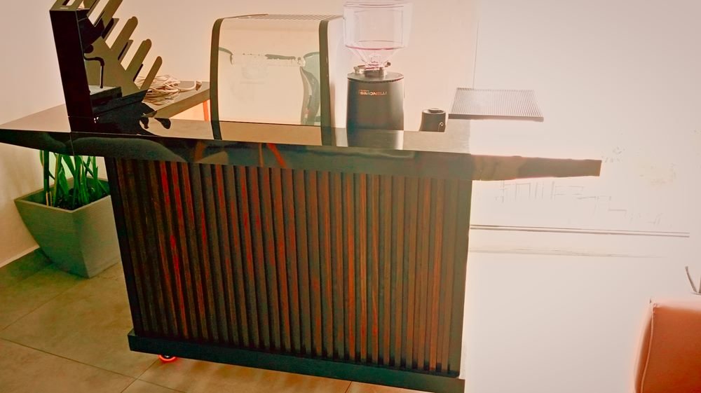 Estación de Café Coffice terminada: cubierta negra, frente de listones de madera oscura, máquina de espresso y molino